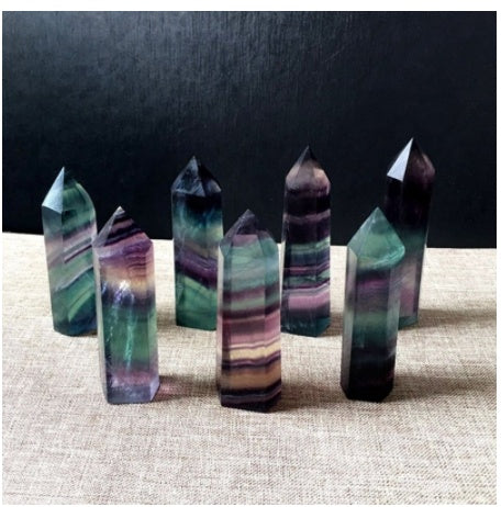 Set of colorful crystal points on a textured surface with a dark background