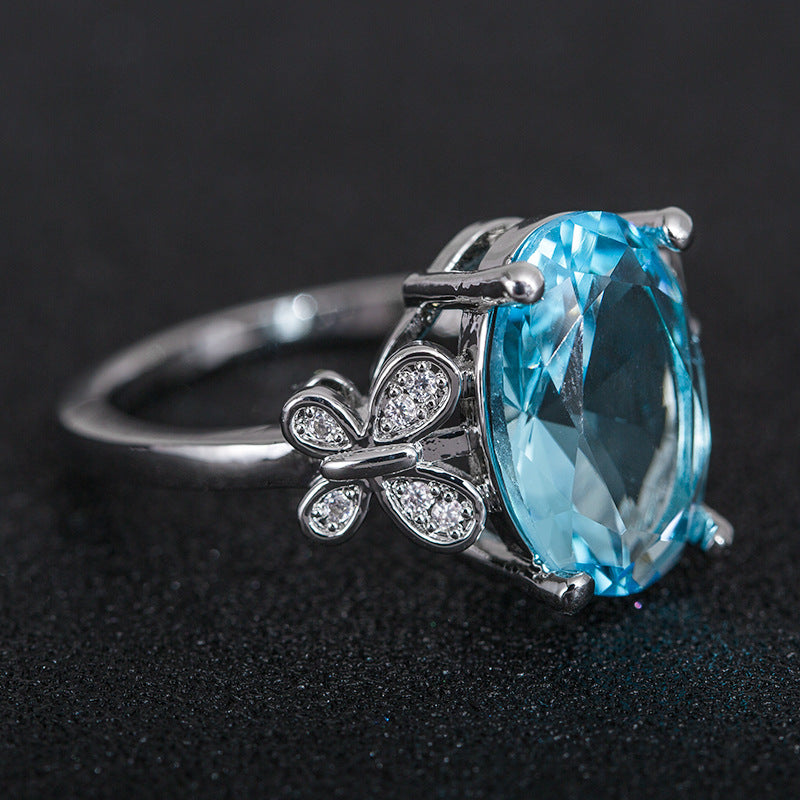 Silver ring with a blue gemstone on a dark background