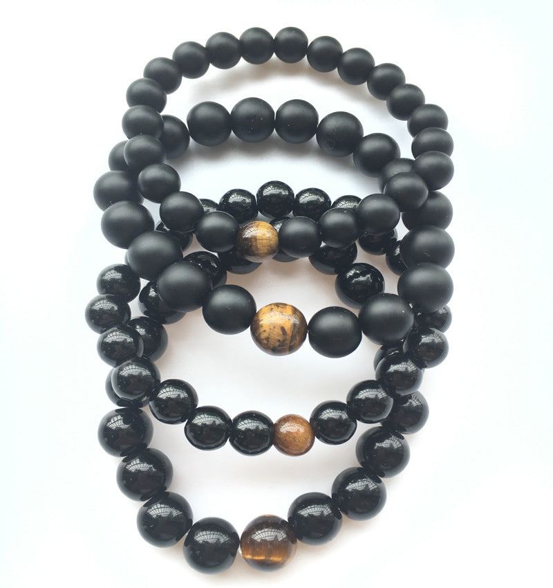 Black beaded bracelet with brown accents on a white background