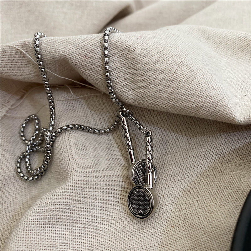 Silver necklace with a pendant on a beige fabric background