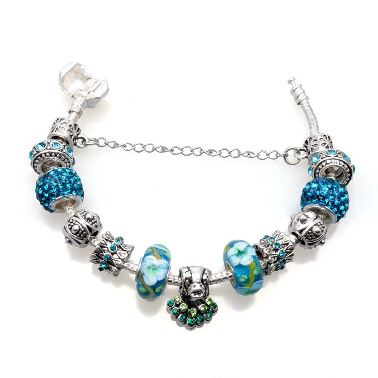 Charm bracelet with blue and silver beads on a white background