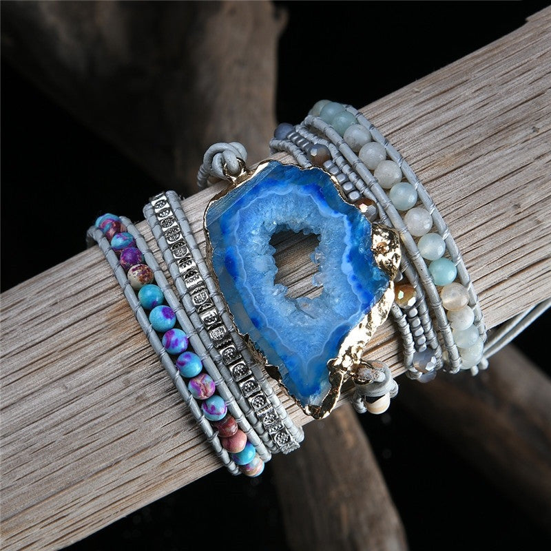 Bracelet with blue geode pendant and colorful beads on a wooden surface