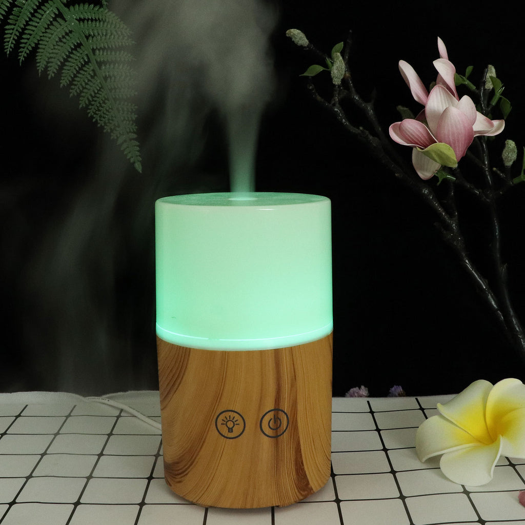 Wooden and green cylindrical humidifier on a checkered surface with flowers in the background