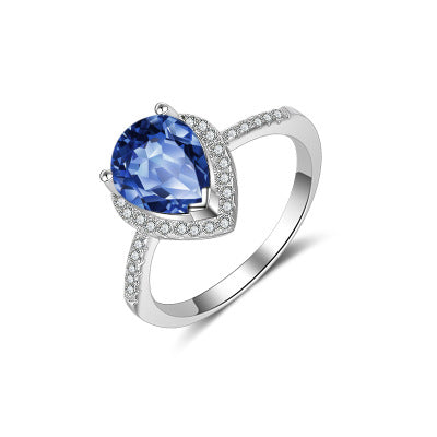 Silver ring with a blue gemstone on a white background