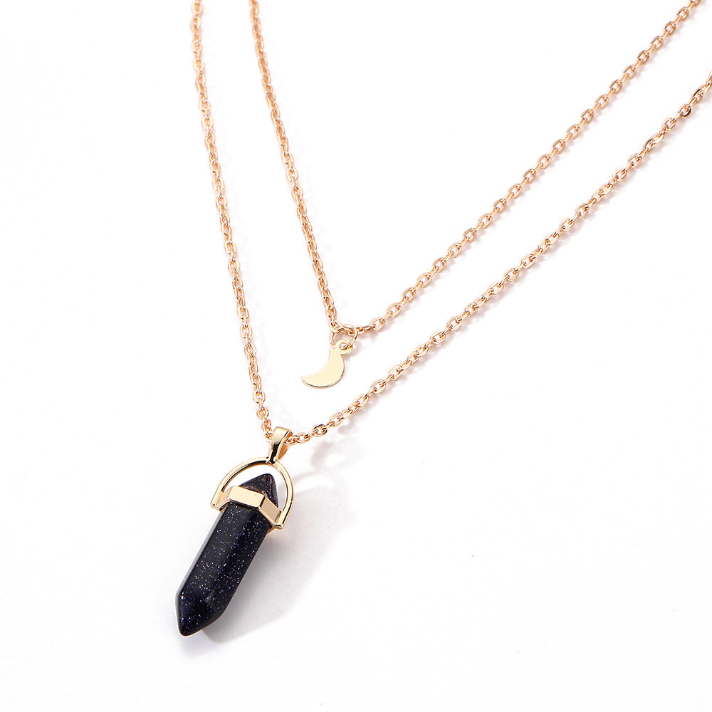 Necklace with a black pendant and gold chain on a white background