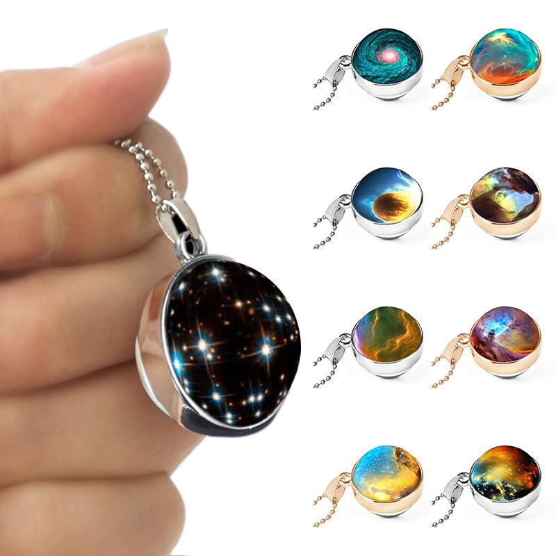 Necklace with a galaxy pendant held by a hand, surrounded by various galaxy-themed pendants.