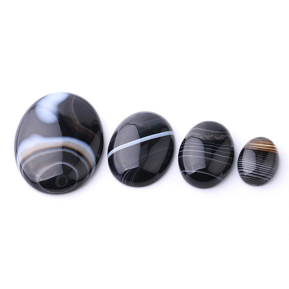 Set of four black and white striped stones on a white background