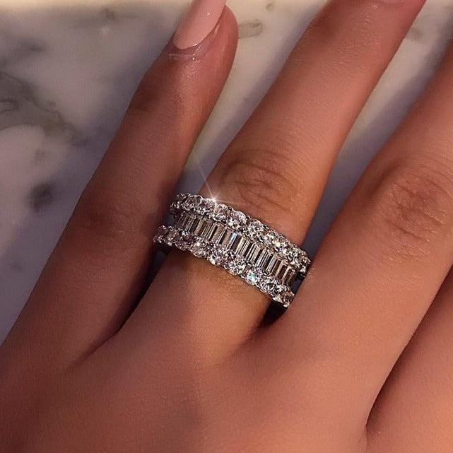 Close-up of a hand wearing a diamond ring on a marble surface