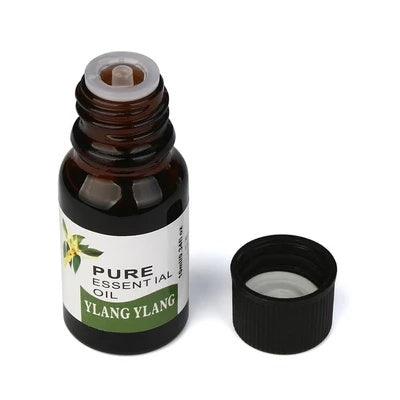 Bottle of pure essential oil labeled 'Ylang Ylang' on a white background
