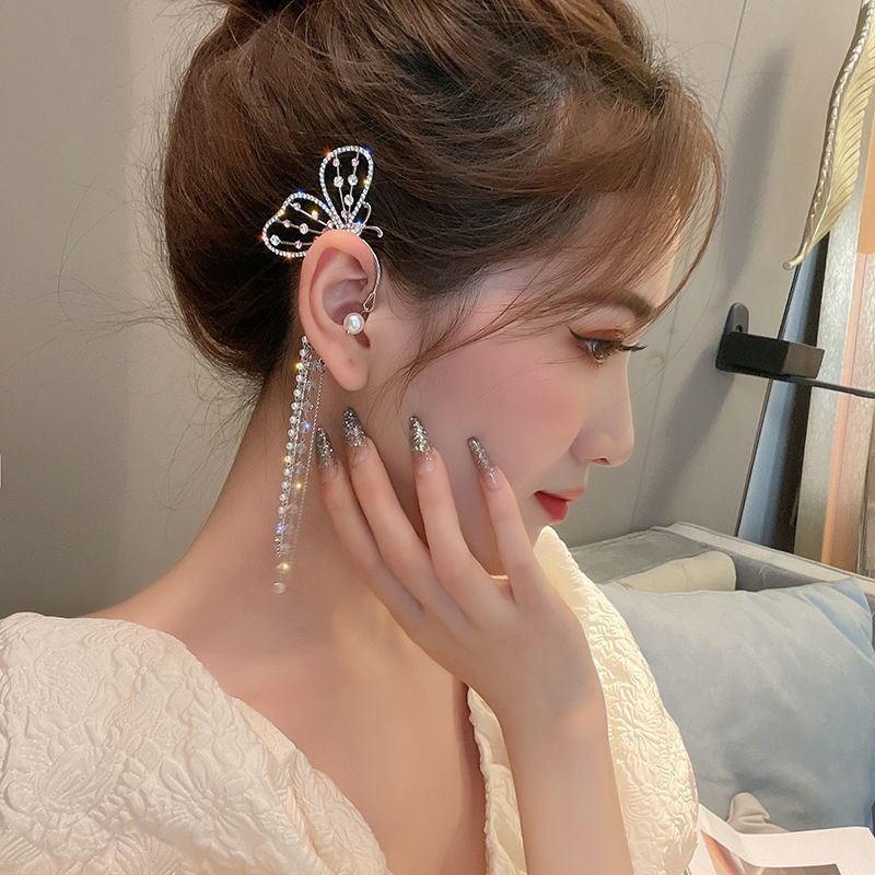 Woman wearing a decorative hairpin and earrings with a neutral background