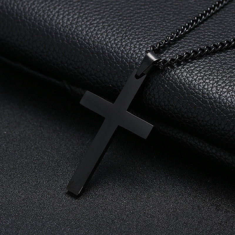Black cross pendant necklace on a black leather background