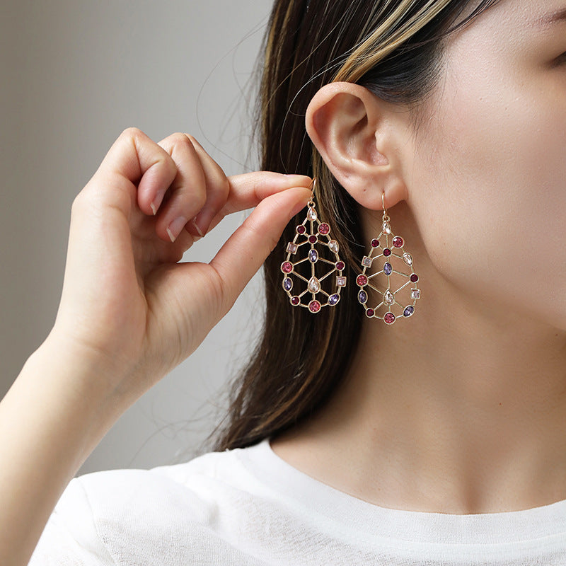 Person wearing intricate earrings with a neutral background