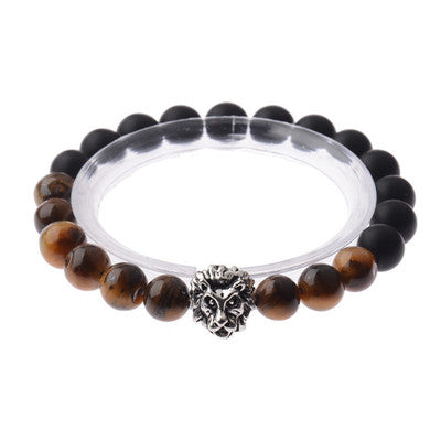 Black and brown beaded bracelet with a silver charm on a white background