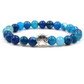 Blue beaded bracelet with a paw charm on a white background