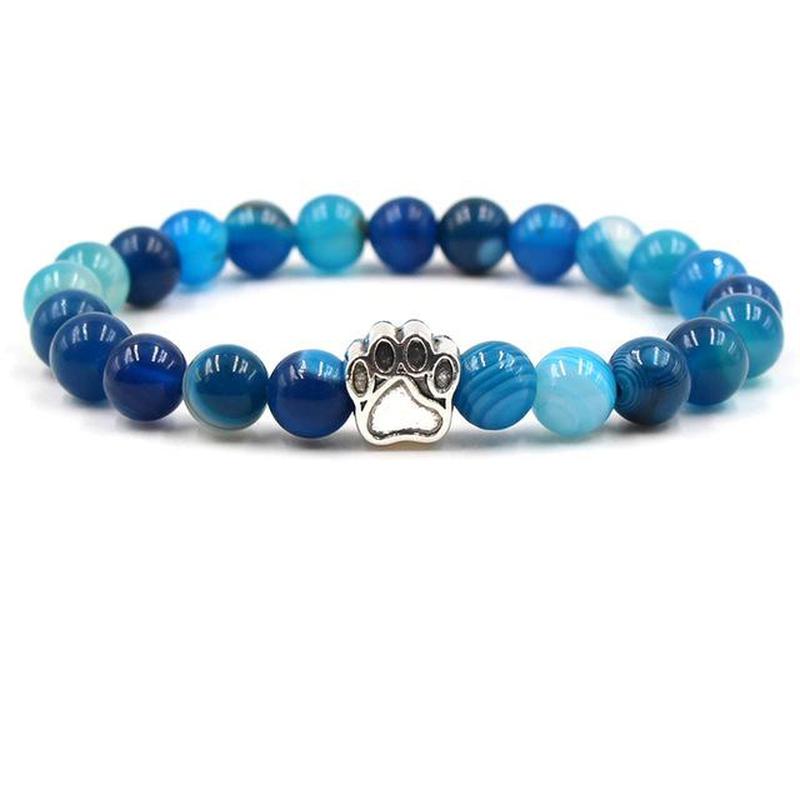 Blue beaded bracelet with a paw charm on a white background