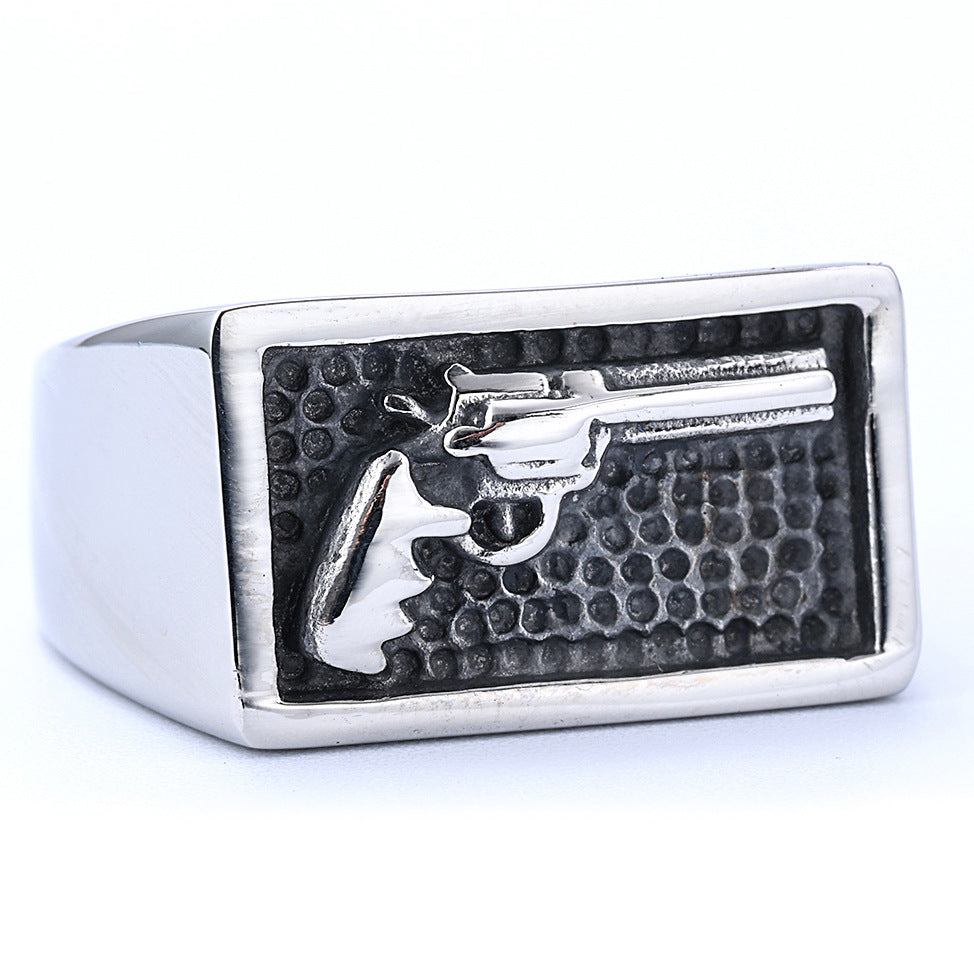 Silver ring with a gun design on a white background