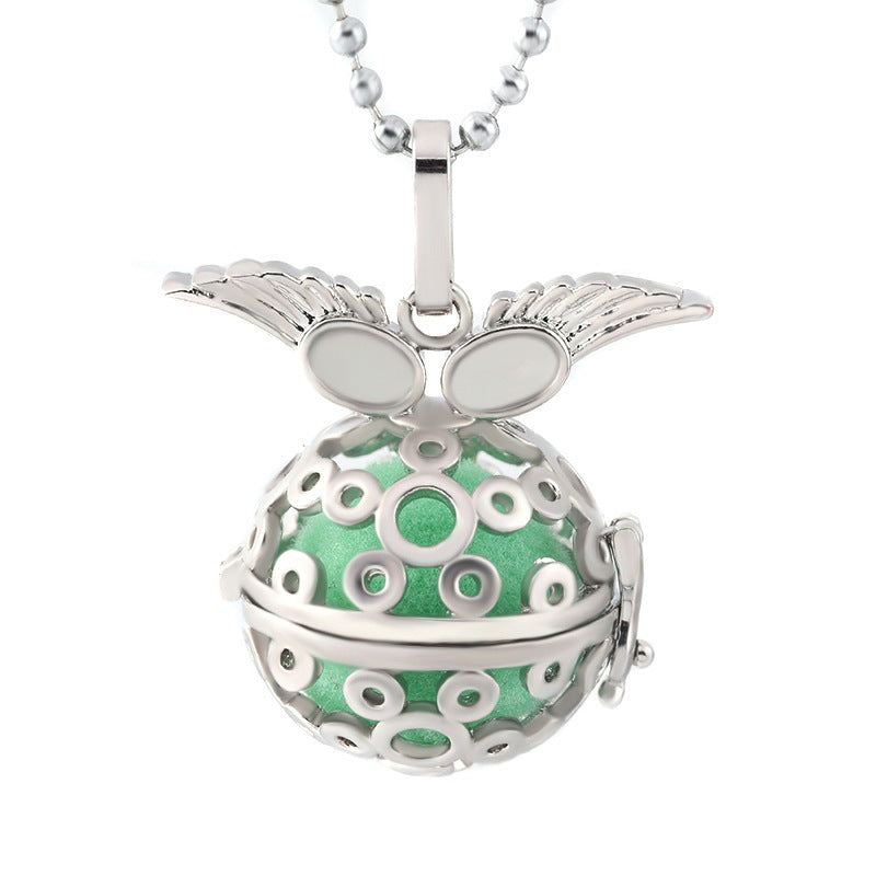 Silver pendant with green sphere and butterfly design on a white background