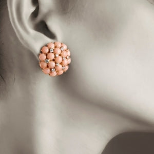 Close-up of a pink beaded earring on an ear.