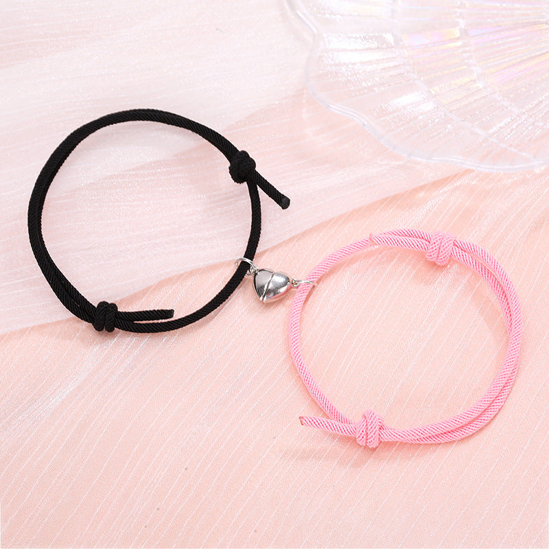 Black and pink bracelets on a soft pink fabric background