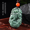 Green jade pendant with red stone on a dark background
