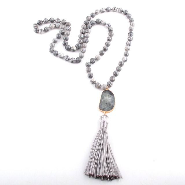 Necklace with gray beads and tassel on a white background