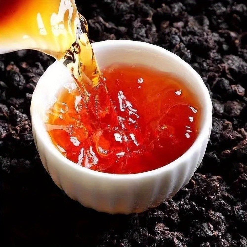 Tea being poured into a white ceramic cup on a dark textured surface