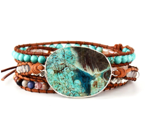 Multistrand bracelet with turquoise stone and brown leather strap on a white background