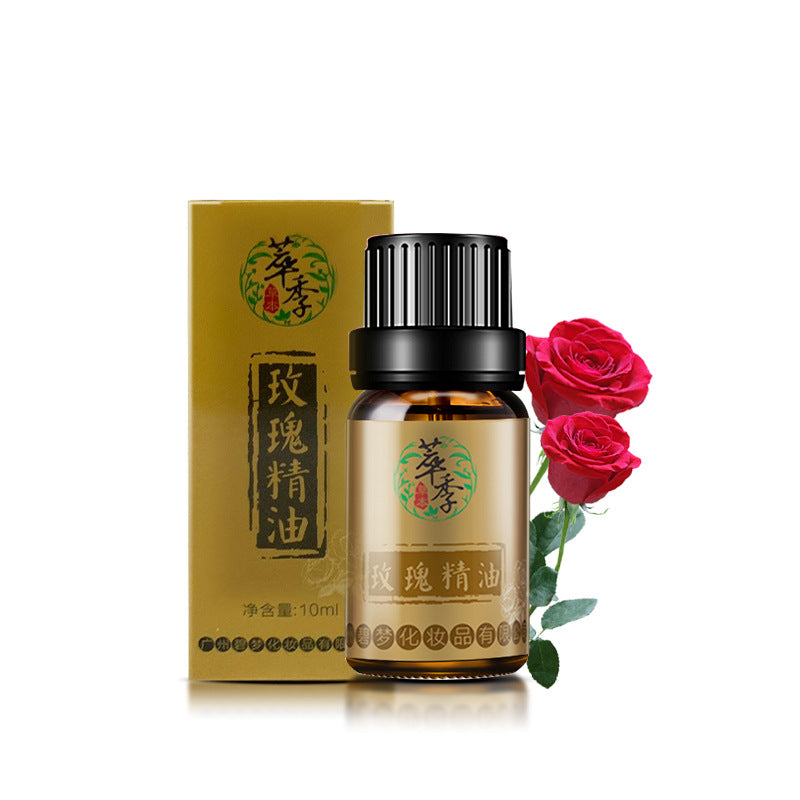 Bottle of rose essential oil with packaging and roses on a white background
