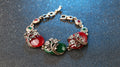 Bracelet with red and green gemstone pendants on a dark background