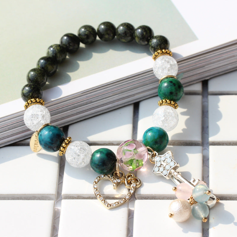 Multicolored beaded bracelet with charms on a white surface