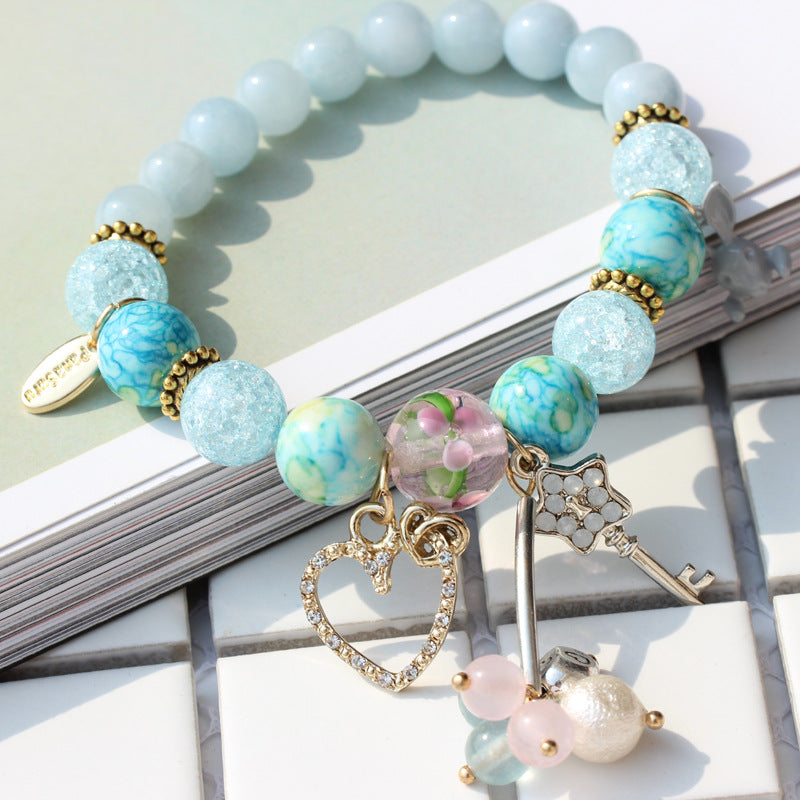 Bracelet with blue and gold beads and charms on a light surface