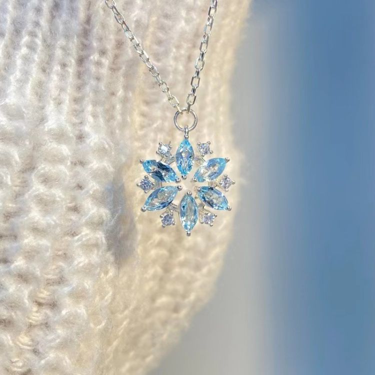 Necklace with a blue gemstone pendant on a textured white background