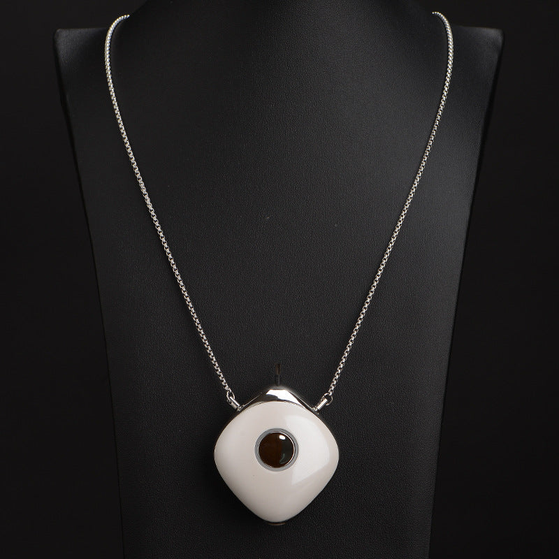 Necklace with a white pendant on a black background