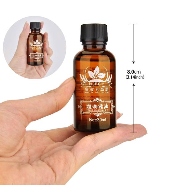 Hand holding a small brown bottle with measurements and details on a white background