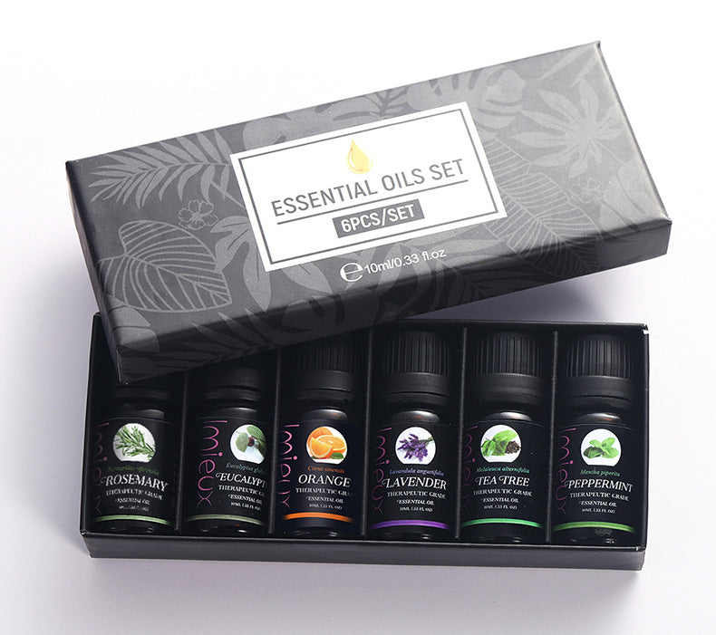 Set of essential oils in a decorative box with labels on a white background