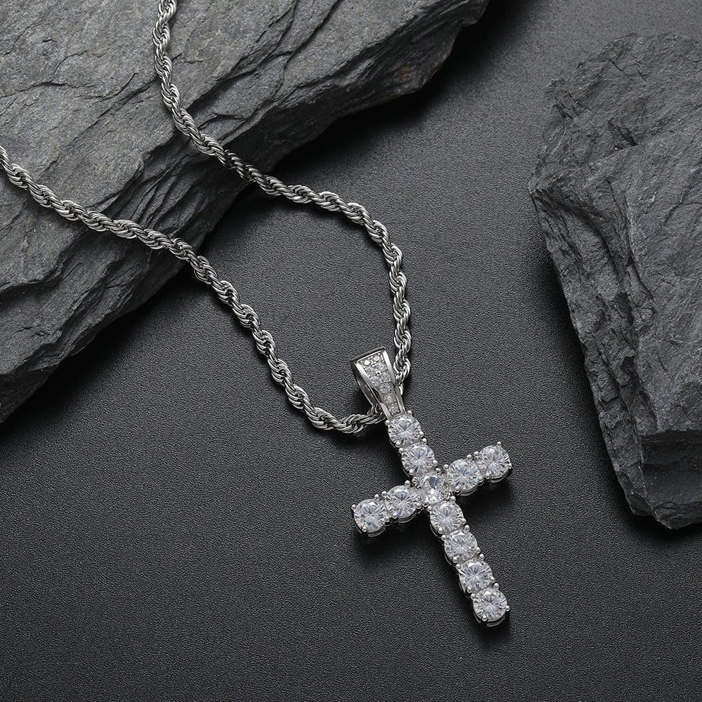 Silver cross pendant necklace on a dark stone surface