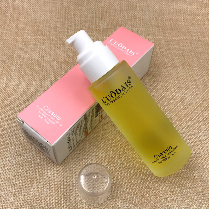 Yellow skincare bottle with pump and pink box on a textured beige surface