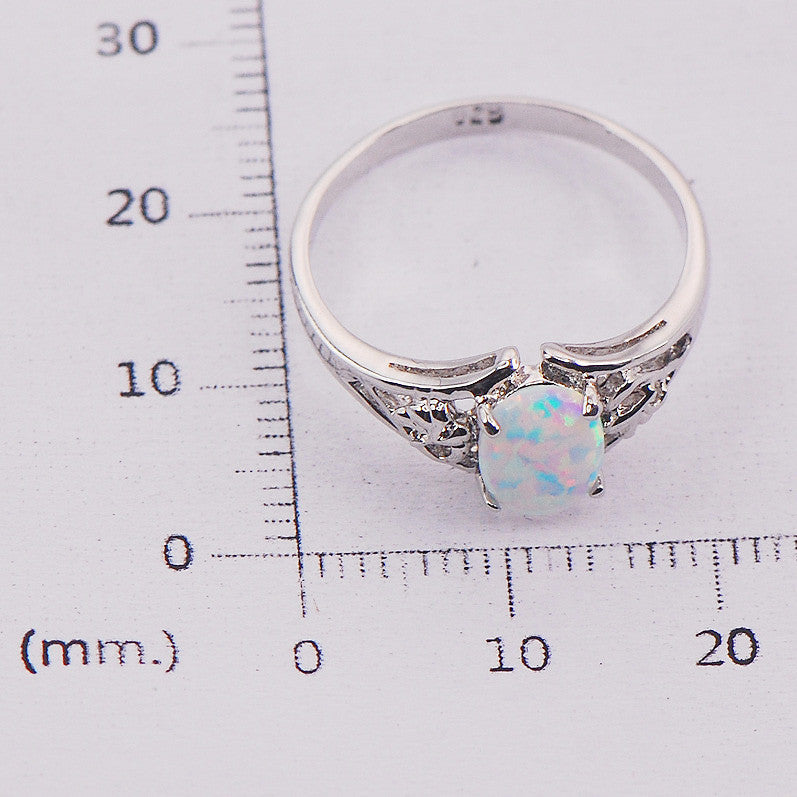 Silver ring with a opal stone on a ruler for size reference