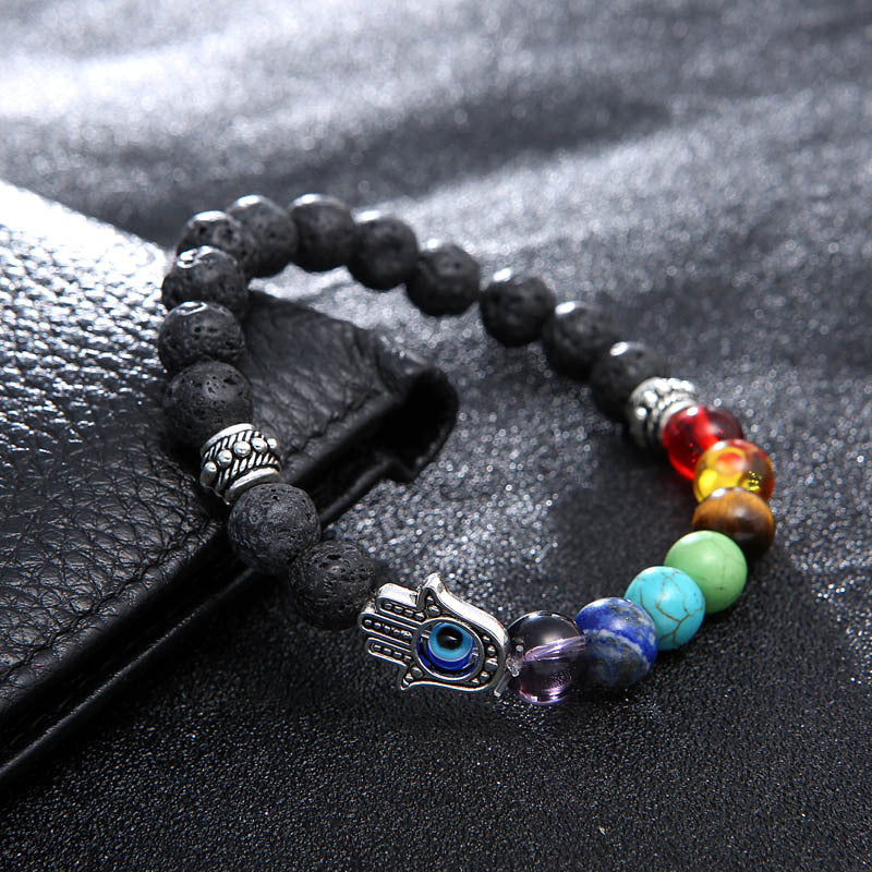 Multicolored beaded bracelet with a Hamsa hand charm on a black surface