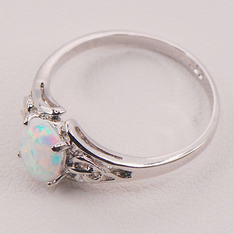 Silver ring with a heart-shaped opal stone on a light gray background