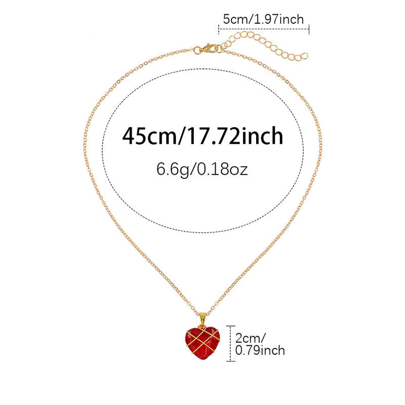 Gold necklace with a red heart pendant and measurements on a white background
