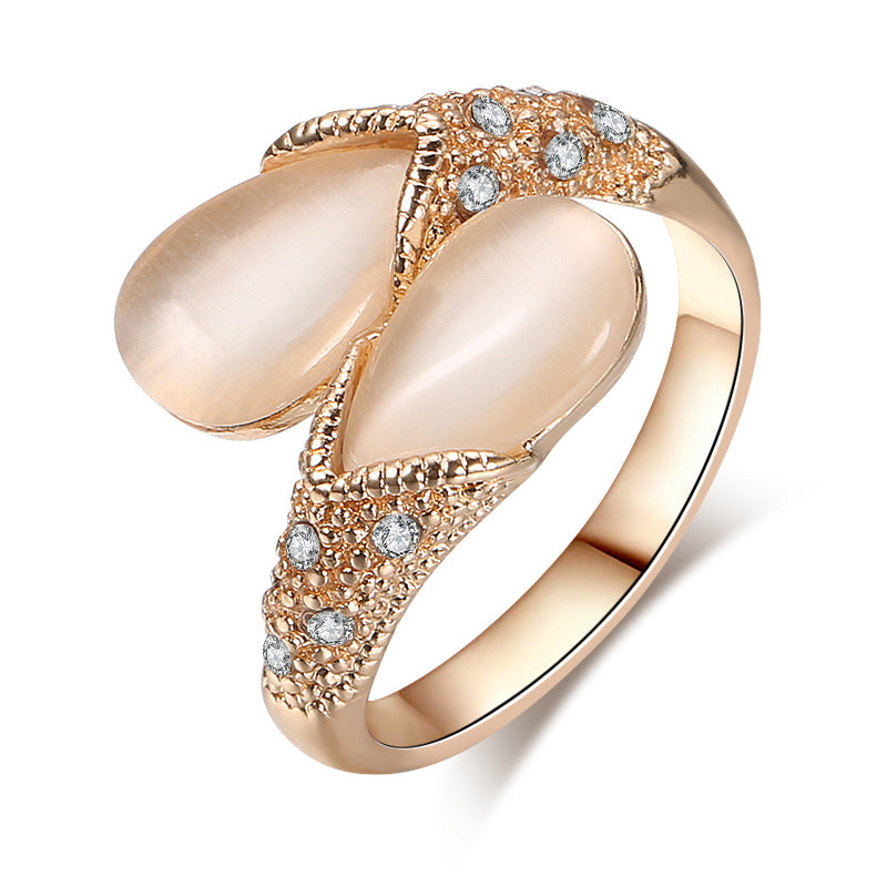 Rose gold ring with pearls and diamonds on a white background