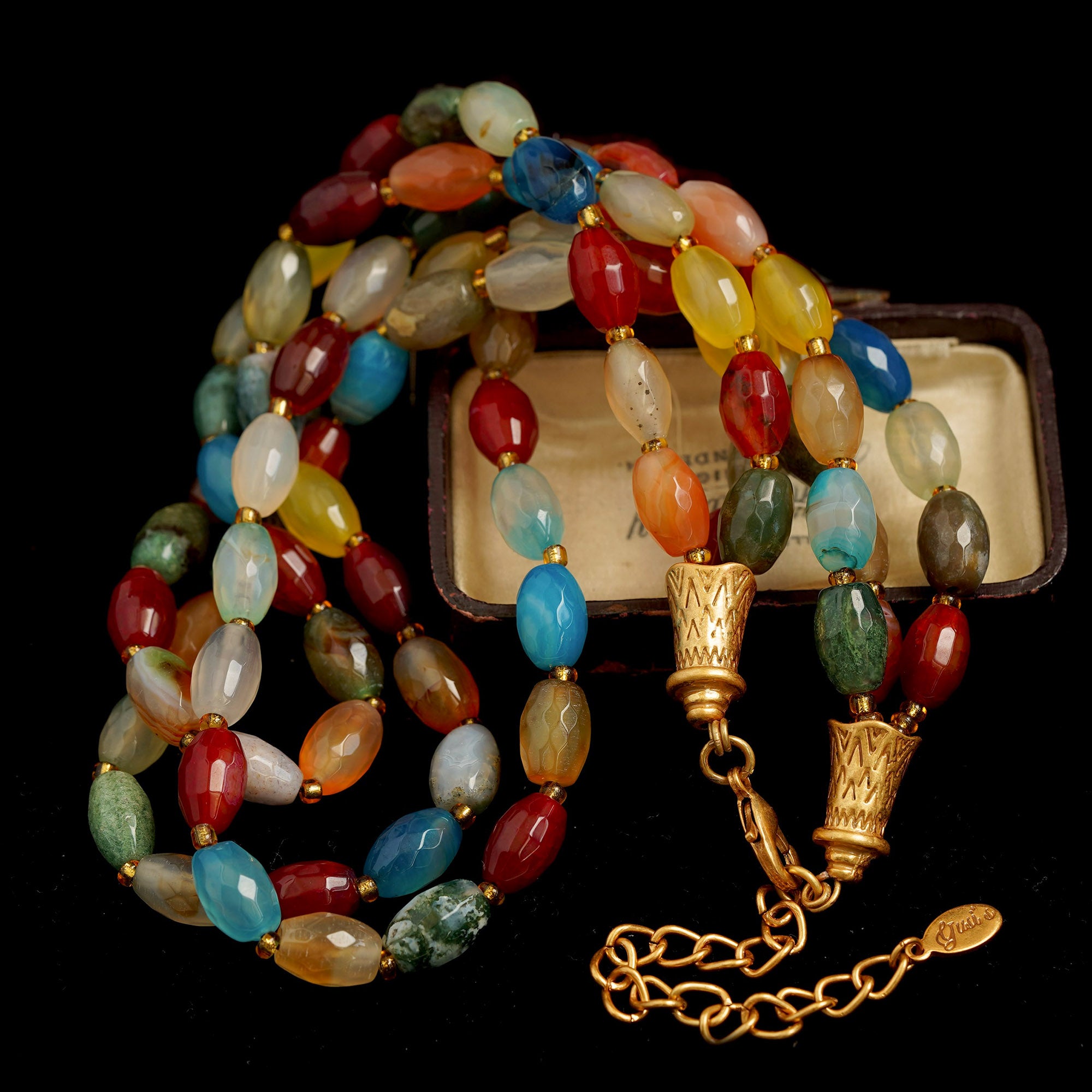 Colorful beaded necklace with gold clasp on a black background