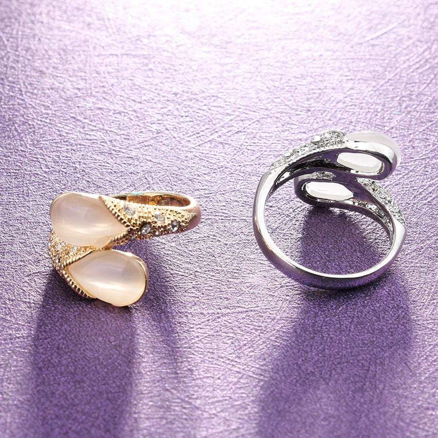 Two rings, one gold and one silver, on a purple textured background
