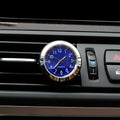Car clock with blue face and silver frame on a car's air vent.