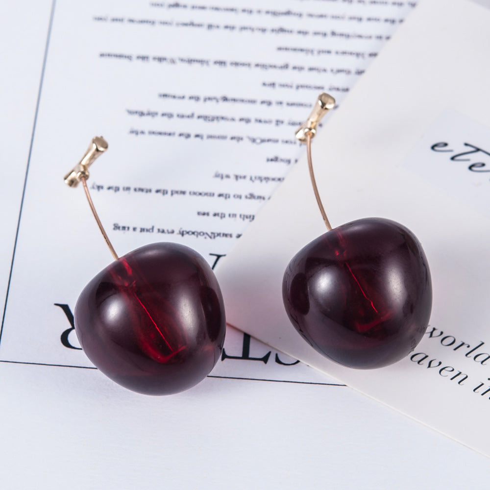Cherry-shaped earrings on a magazine page