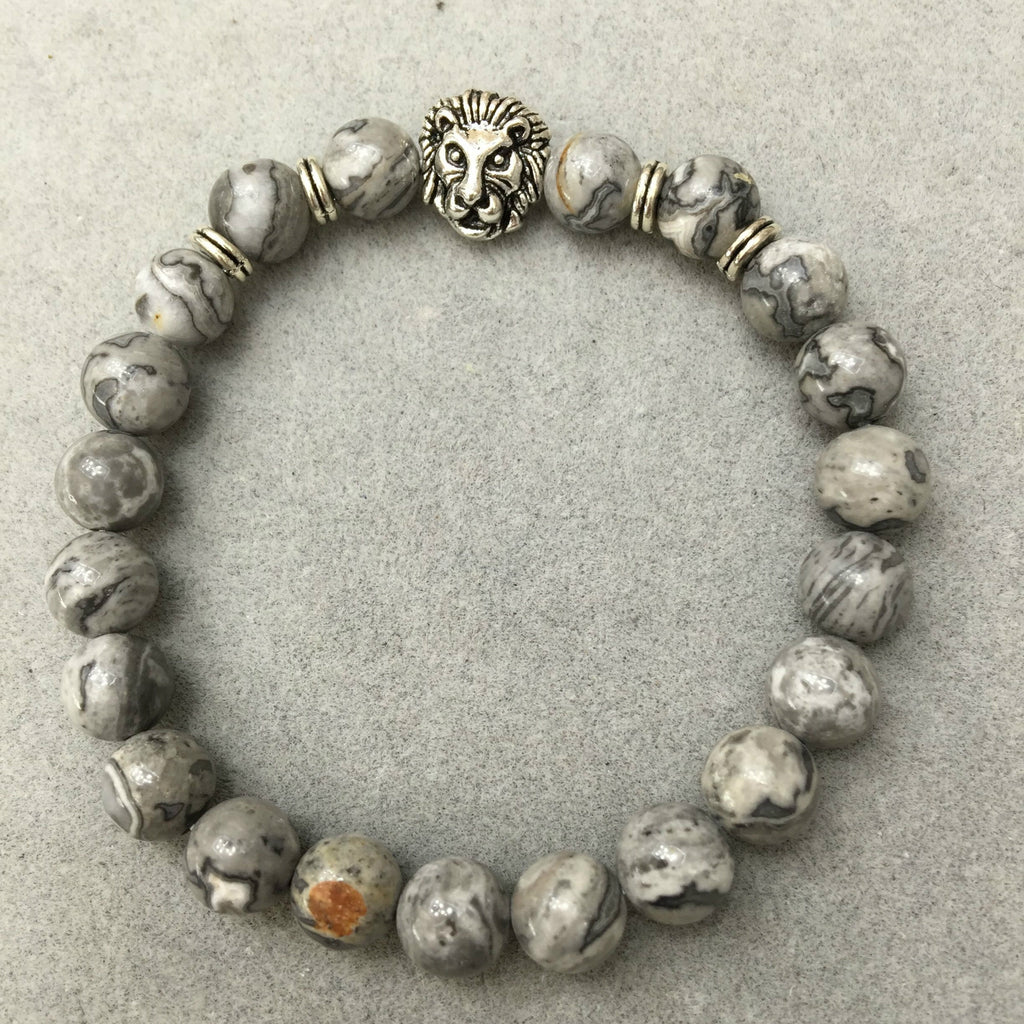 Beaded bracelet with lion head charm on a gray background