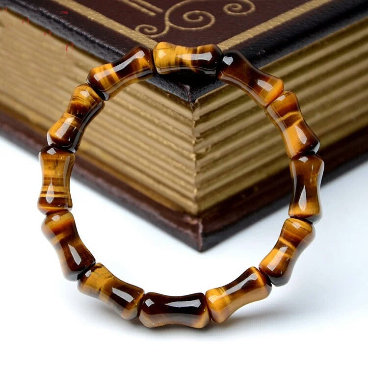 Tiger eye bracelet on a white surface with a book in the background