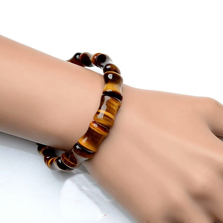 Tiger eye bracelet on a wrist against a white background
