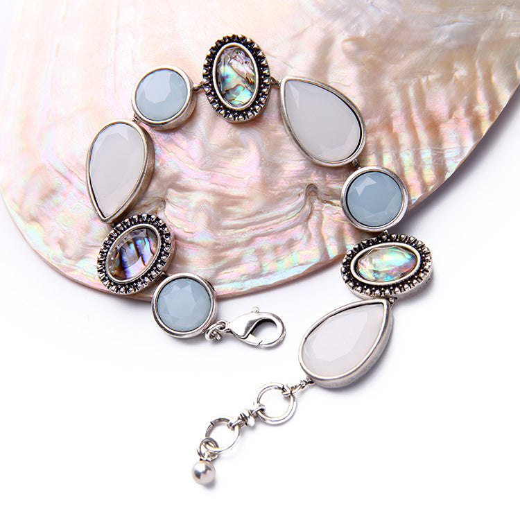 Bracelet with teardrop-shaped gemstones on a shell background